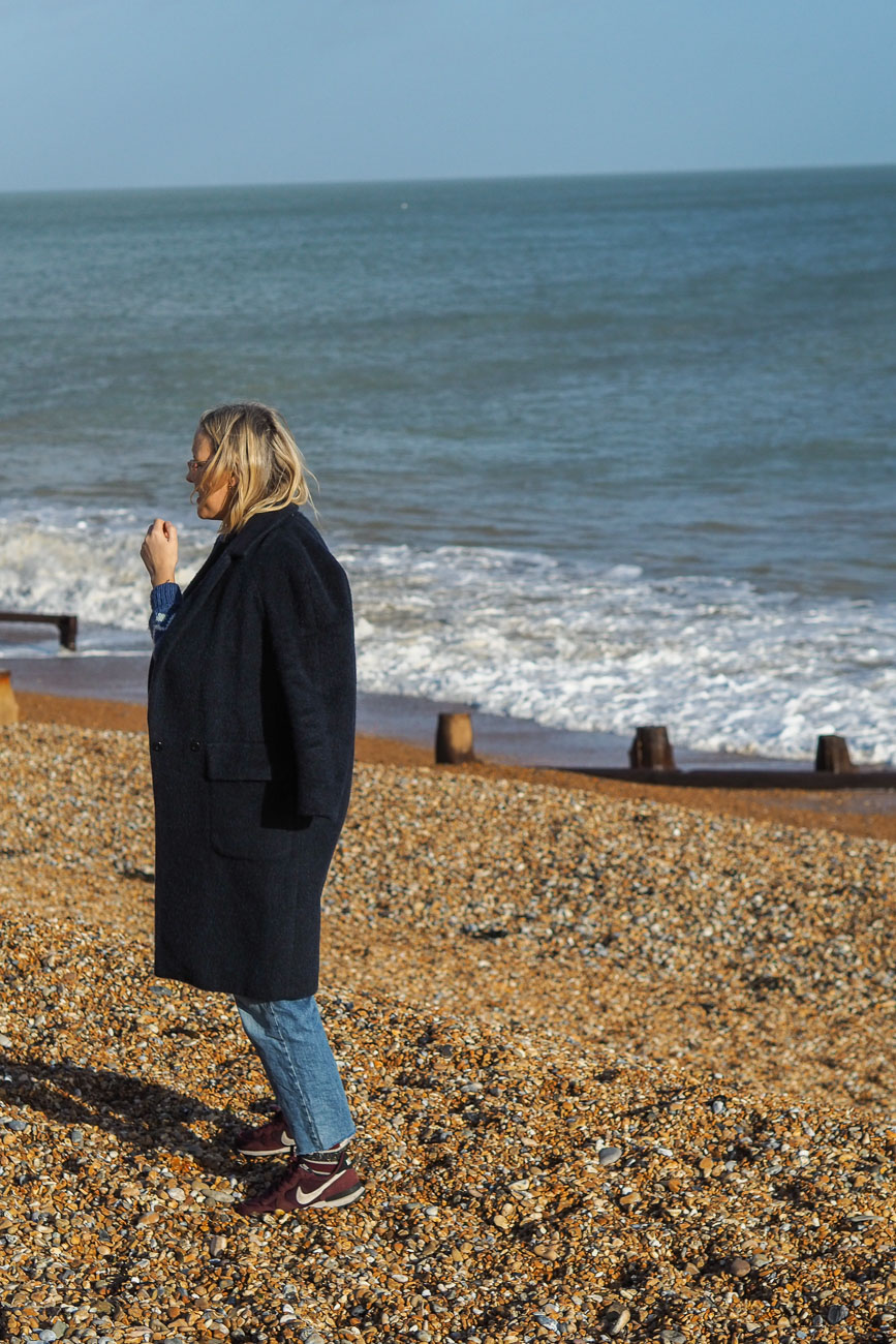 Alexandra Stedman of The Frugality walking along Deal's pebbly beach.